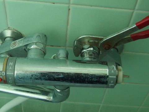 古いシャワー混合水栓をウォータープライヤーなどの工具を使って外します。六角ナットの部分をこちらから見て時計回りに回すと外れます。